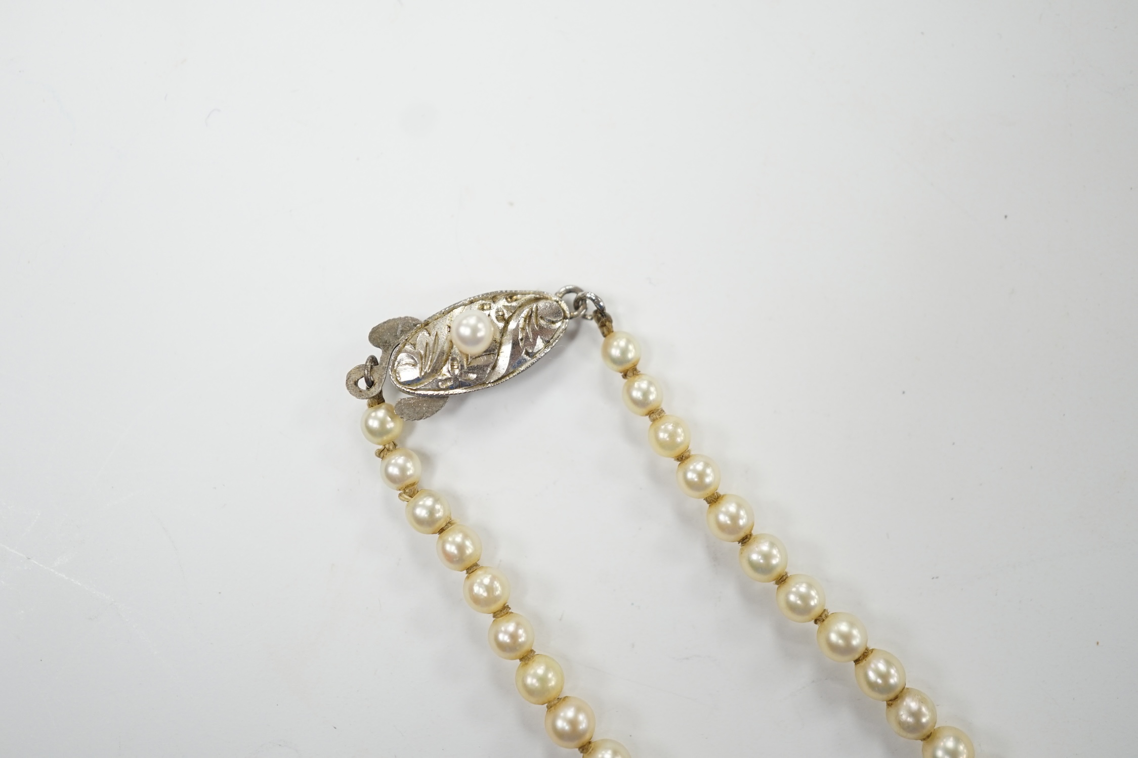 A single strand graduated culture pearl necklace, with cultured pearl set white metal clasp stamped 'silver', 38cm. Fair condition.